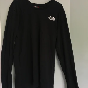 The North Face longsleev  - Säljer The North Face longsleev pga använder inte längre. Det är en bra svart färg på tröjan men trycket bak har spruckit. 