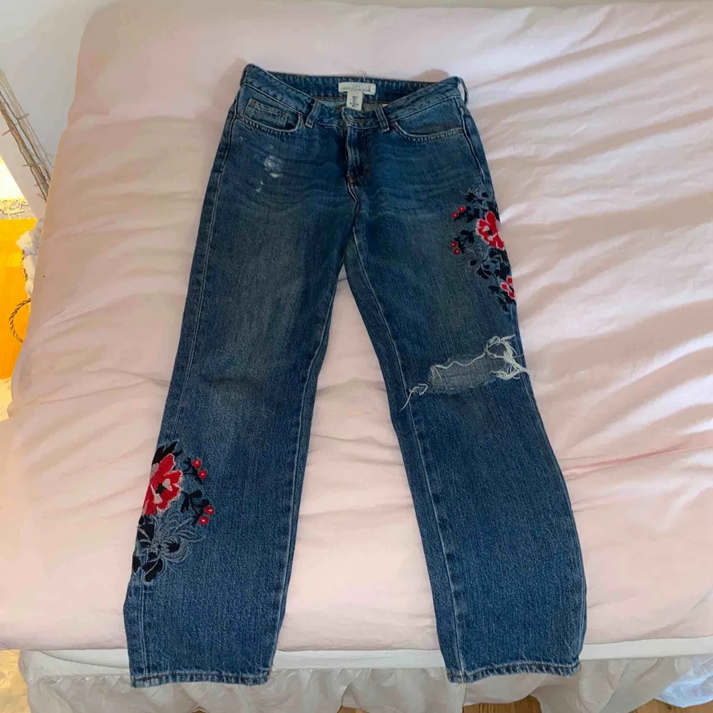 (Gamla bilder!) Säljer mina favorit-jeans pga för små. De passar strl 34-36. Blåa jeans med broderade blommor och hål på knät. Använda mycket men är i gott skick! Kan mötas upp eller frakta, köparen står för frakt✨🦋. Jeans & Byxor.