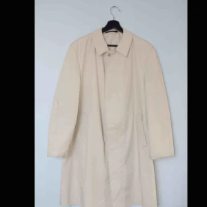  - Säljer en beige rock i en car/mac-modell, av märket Valmeline, med dold knäppning!  Size: Medium Cond: 9/10 (inga tydliga tecken på användning, hål i inre bröstfickan - lätt att åtgärda)