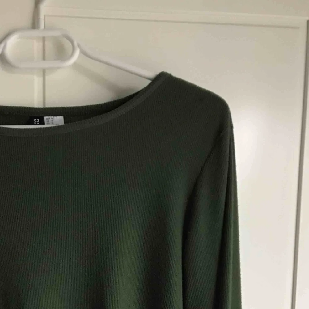 Ribbad mörkgrön tröja med detaljer i ärmar och vid magen. Passar även storlek L.  Köparen står för frakt ;). Toppar.