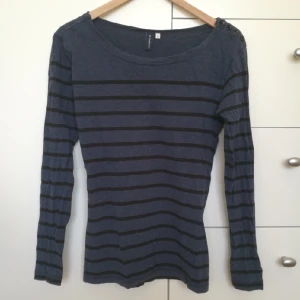  - Snygg och knappt använd tröja från Sunshine med knappdetaljer på ena axeln. Kan mötas upp i centrala Stockholm eller posta (köparen betalar frakten).