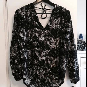  - Blus från Nelly med djup rygg 