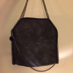 - Superfin väska i grått/svart med kedjor i silver och vackert rosa sidenfoder. Priset kan diskuteras vid snabb och smidig affär. Om väskan ska fraktas tillkommer 60 kr. 