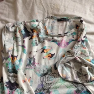  - En ganska urtvättad t-shirt med ett psykedeliskt mäster! 