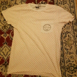  - snygg vit tröja från wesc tillsammans med happy socks med orangea prickar och märke på fickan 