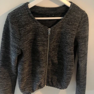 Grå kofta/tröja - Säljer denna då den är för liten. Ej sliten. Resår längst ner. Stabil dragkedja.