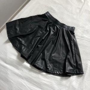 Bershka kjol - En supersnygg svart kjol i blankt tunt material från Bershka. Storlek XS. Inkl frakt.