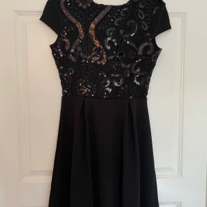 Svart klänning med öppen rygg - En oanvänd svart klänning med öppen rygg. Storlek S.