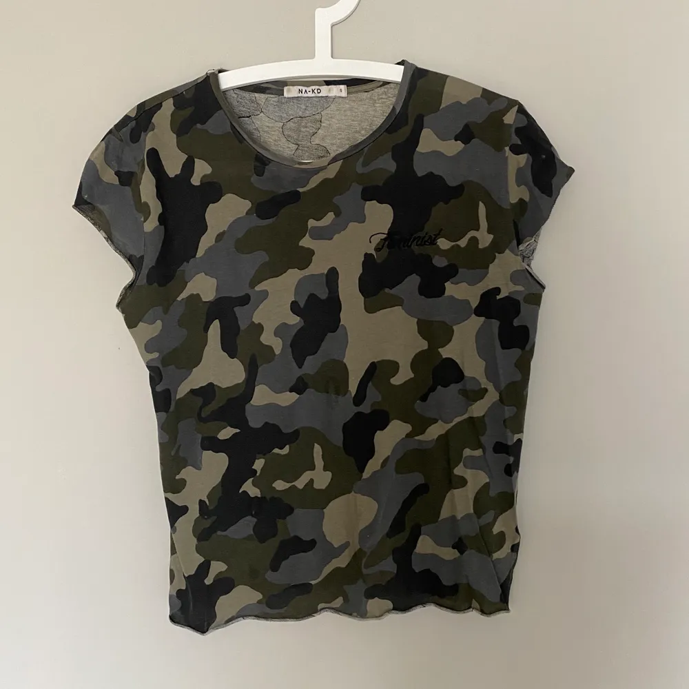 Trendig T-shirt med militär-tryck och feminist broderat på. T-shirts.