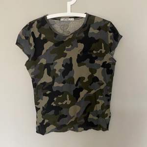 Trendig T-shirt med militär-tryck och feminist broderat på
