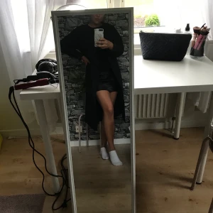 Tunn svart kappa - Perfekt sensommar/höstkappa med band runt midjan. Kappan är lite längre i modellen. Använd ett fåtal gånger. 