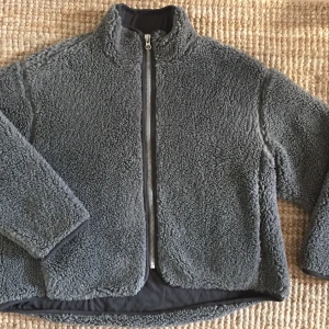 Teddyflece Weekday - Grå teddyflece, sparsamt använd och mycket varm! Yttertyg: 66% polyester, 34% aktyl Fodertyg: 100% polyester 