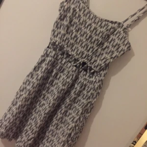  - Mönstrad klänning med "hål" under brösten. Något tajt över brösten. 