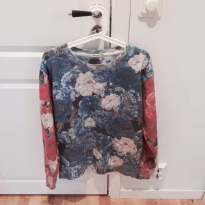  - Collagetröja från River Island med blommigt print. Använd ett fåtal gånger, i fint skick! I skönt material och mycket mjuk på insidan. Kan skicka fler bilder vid intresse! Möts upp i Stockholm eller skickas med post, tar swish! 