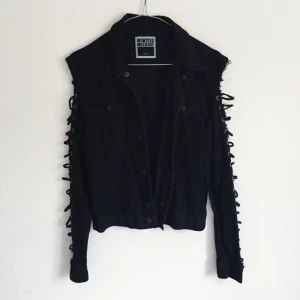  - Tuff svart jeansjacka från weekday med öppna ärmar. Den är använd och lite sliten i jeanstyget, men bara på ett snyggt sätt. Den är märkt S men liten i storleken, så passar även en XS. Frakt 49kr 