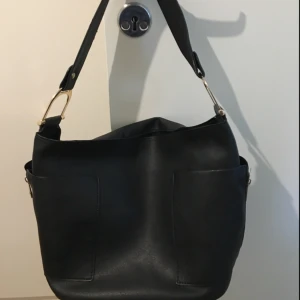  - Snygg väska från Åhlens med dragkedjor på sidorna. 2 innerfickor. Inga skador! Köpt för 500kr.