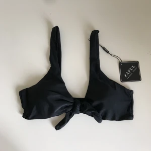  - Svart elegant bikini Top med knut från Zaful. Säljes pga att jag beställt fel storlek. Frakt betalas själv om ingen annan överenskommelse. Aldrig använd!