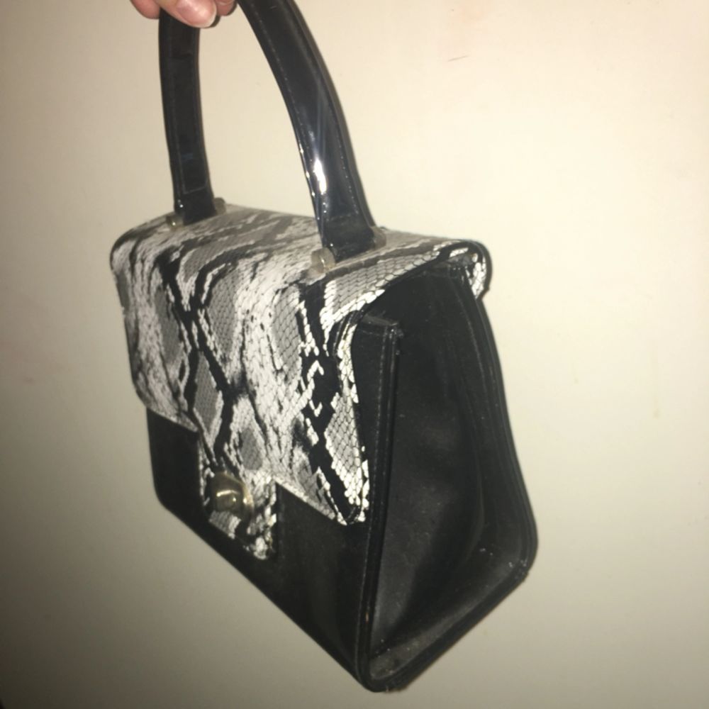 Söt svart handväska med ”ormskinn” (inte riktigt). Lite märken inuti men inget som märks. Möter upp i Malmö/Lund eller fraktar (köparen betalar).. Väskor.