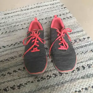 Ett par grå/neon rosa skechers. Jätte sköna tränings skor använda några fåtal gånger. De är i storlek 39,5 men är ganska stora i storleken. Original pris 999kr 