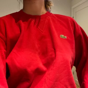 Lacoste  - Röd lacoste tjocktröja. En skön tröja med lite tjockare tyg. Sitter jättebra och är i jättebra skick. 