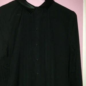 Svart skjorta med krage i skinnimitation och nitar till knappar. Snygg och skön från HM - Svart skjorta med krage i skinnimitation och nitar till knappar. Snygg och skön från HM