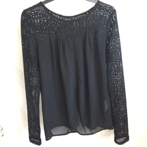  - Fin svart blus med spetsarmar, ganska genomskinlig men bh-n brukar inte synas igenom så mycket. Använd fåtal gånger, detalj (se sista bilden) på både bak och framsidan