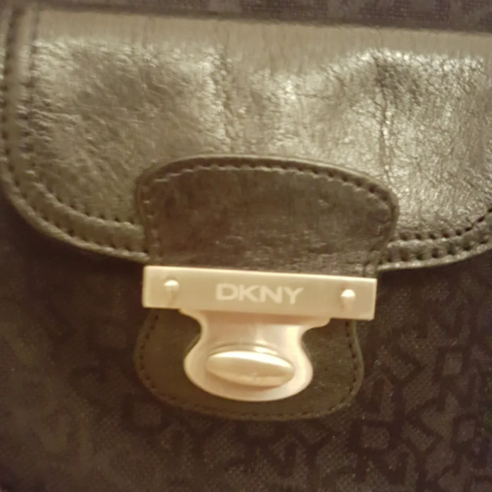 Äkta DKNY väska i tyg med skinndetaljer. Använd men i bra skick. . Väskor.