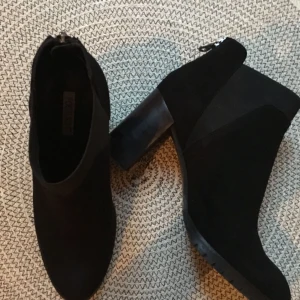  - Svarta stövletter tillverkade i mocka med resor på sidorna. Storlek 39,5 med en ganska smal läst. Klackhöjden är 7,5 och är bekväma att gå i. Fint skick! Nypris 1800kr