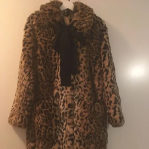  - =NY!!= ERDEM x H&M.  En rakt skuren kappa i mjuk pälsimitation med leopardmönster. Kappan har krage och avtagbart ripsband i nacken som knyts fram. Dolda tryckknappar samt utanpåfickor fram.  Storlek 34 men passar absolut även 36