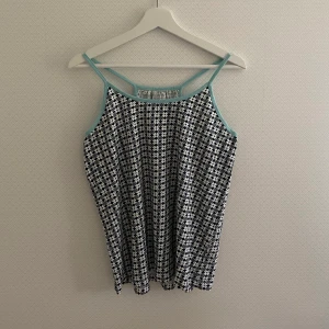 Mönstrat linne - Mönstrat linne med turkosa band från Etirel:) Kan vara fin att croppa;) Frakt: 22kr (brev)