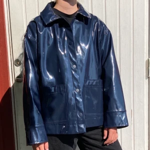 Lackjacka från Weekday, strl L - Mörkblå lackjacka från Weekday, strl L. Använd ett par gånger, så är så gott som i nyskick. Snygg som oversize och praktisk på hösten eftersom materialet är vattenavstötande! Köparen står för frakt.