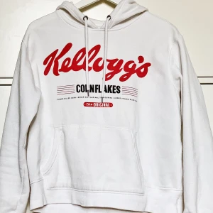 Hoodie med tryck - Alla som älskar Kellogg’s BEHÖVER den här hoodien i sin garderob! Knappt använd i perfekt skick. Snyggt tryck över bröstet, och bra passform för en XS-M beroende på hur man önskar att den ska sitta! 