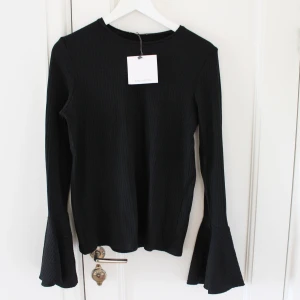 Ribbad topp - Oanvänd ribbad topp med vid ärmslut. 🤍 Köparen står för frakt. Hör av dig om fler bilder önskas eller om du har någon annan fråga.