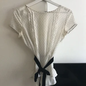 Prickig blus  - Prickig blus med svart midjemått skärp med dragkedja 