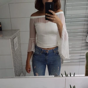 Vit croppad topp från GUESS - En jättegullig vit croppad topp från GUESS med superfina ärmar.  Nypris 700, aldrig använd så den är i nyskick. 