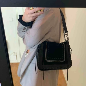  - Svart väska i både skinn och mocka med silverdetaljer ursprungligen från Zara. Man kan både ha den som en axelväska och cross body. Väl använd men i superbra skick. 