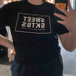  - En svart t-shirt från Sweet Sktbs! Sparsamt använd men har dock en liten blå fläck på ena armen som man ser på bild 3, men det syns knappt! Passformen är normal xs om man vill ha den oversized och även en mindre L! Frakten ingår i priset🧡