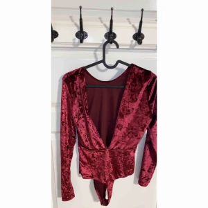  - Vinröd sammet body med låg urringning i ryggen. Bara testad