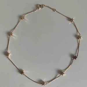  - Guldig choker med stjärnor. 40 cm runt halsen. En av stjärnorna är mörkare en dom andra, men det märks inte när man har på sig den. Är fin med det mesta.