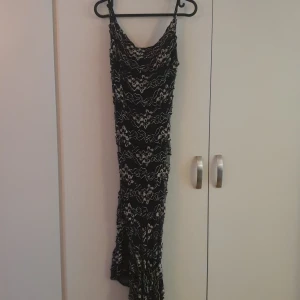 Långklänning  - Svart mönstrad klänning, aldrig använd.
