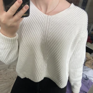 Vit stickad tröja från HM, stl: XS  - Vit stickad tröja från HM, köpt för några år sedan men inte kommit till användning, v-ringad, vid axeln går en söm (se bild 2), kortare fram än bak (se bild 3) säljer pga använder ej 