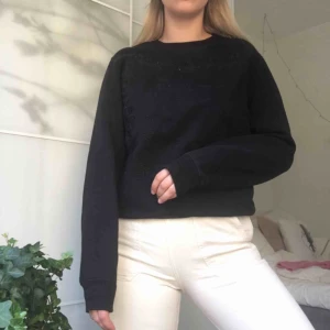  - Superfin strukturerad tröja från & Other Stories med broderat mönster framtill. Svart. Frakt ingår ej.