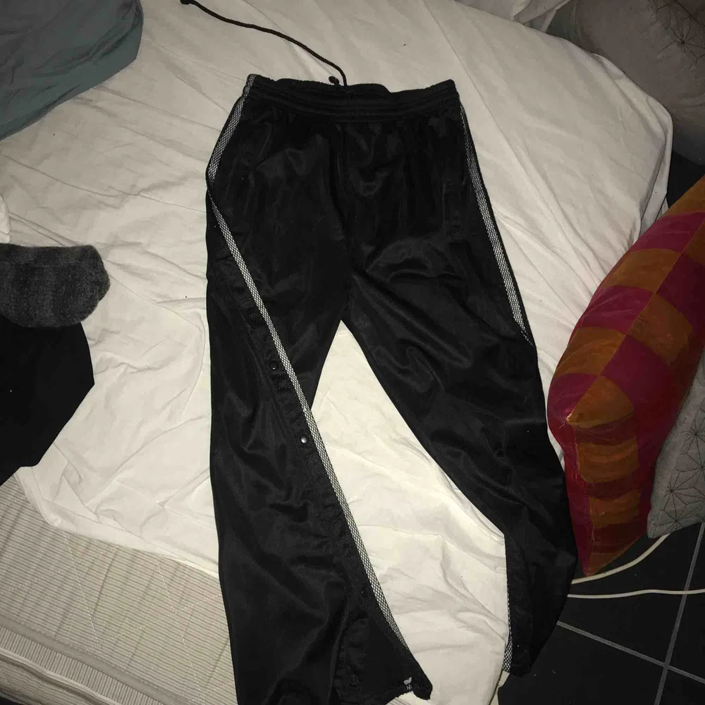 Ascoola svarta  trackpants med knappar och mesh längs benen! Använda men i bra skick!! Endast nån knapp som är trasig men det märks knappt:) Stål L i men jag har typ S o de funkar bra, man kan dra åt i midjan. köpare stör för frakt!. Jeans & Byxor.