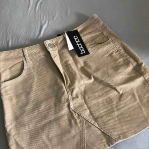  - Oanvänd sandfärgad kjol köpt från Boohoo stl 38.  Kan mötas upp i Malmö/Lund, annars står köparen för frakt! 