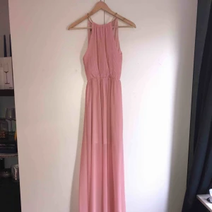  - Ljusrosa långklänning med guldig detalj uppe vid halsen, storlek M men passar S. Aldrig använd, köpte den för att ha på balen i 9an men ångrade mig sen och köpte en annan. Köparen står för frakt, kan mötas upp i Lund/Malmö 