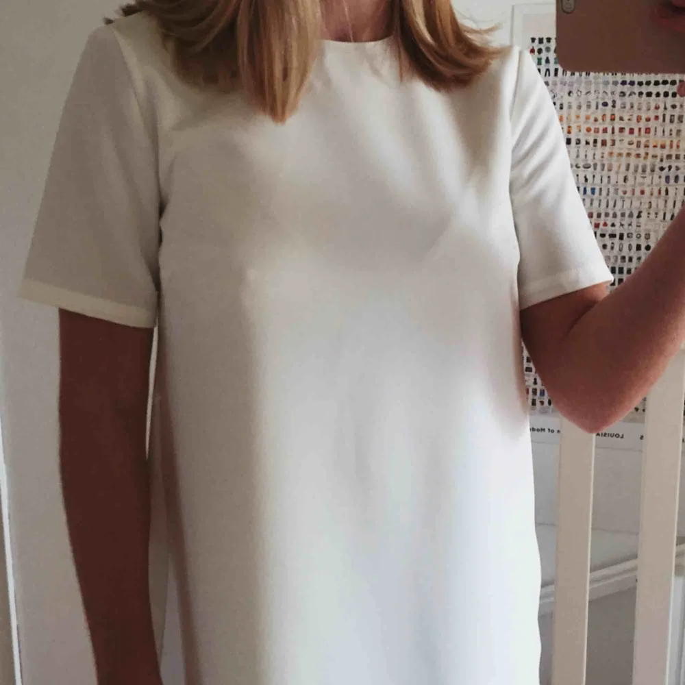 Enkel vit klänning i rak modell, köpt på Nelly.com förra året till min student, men använde den aldrig. Den är därför helt ny, endast provad. Kostade 300kr. Slutar en bit ovanför knäna på mig som är 1,63cm. Dubbelt tyg gör att den inte är genomskinlig.. Klänningar.