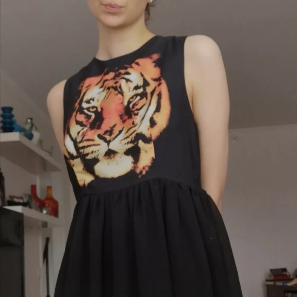 Svart klänning med tiger på. Mycket fint skick, knappt använd. Klänningar.