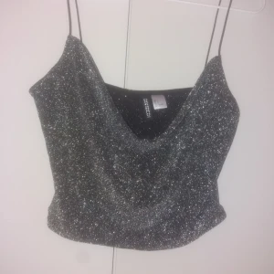  - En silvrig glittrig kort tröja perfekt för nyår osv banden e väldigt tunna 