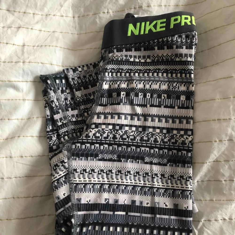 Mönstrade Nike Pro träningstights med grön logga på benet, använda men är i bra skick! Köparen står för frakten💕. Jeans & Byxor.