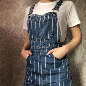 Jeansklänning strl 36 - Fin, randig jeansklänning-ish från hm, inköpt för några år sedan. Jättefint skick trots att den är använd. Det finns en dragkedja på vänstra sidan och hängslen går att knäppa bort där fram. Köparen står för frakt!🌻